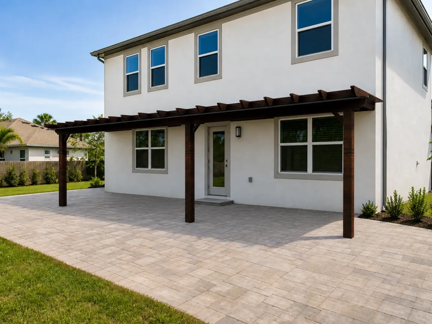 Visualisation of a dark timber pergola extending across the paved terrace of a white house.